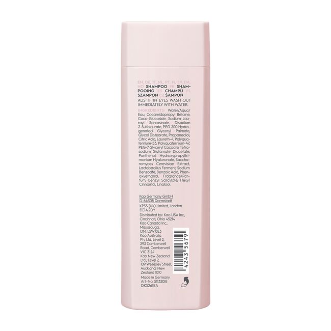 Back of a pink shampoo bottle with text and a barcode on a white background