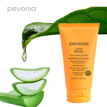 Pevonia sunscreen tube with aloe vera slices and leaves on a white background