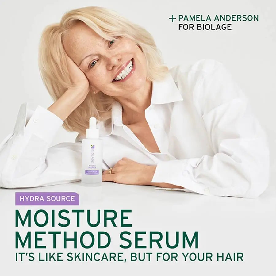 Woman with blonde hair holding a bottle of Biolage serum, with text about the product and Pamela Anderson's involvement.