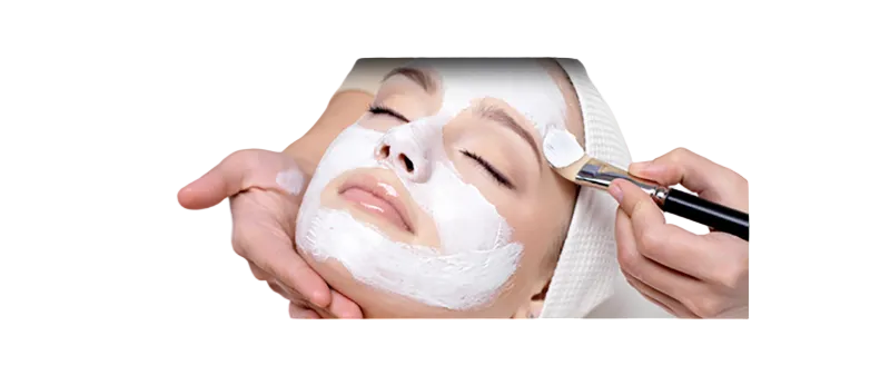 Person applying a facial mask to another person's face with a brush.